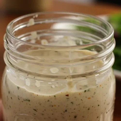 Homemade Texas Roadhouse Italian dressing in a mason jar shows a creamy, emulsified texture.