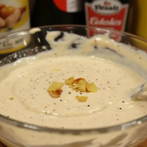 A photo of Donkey Sauce in a bowl, with mayonnaise, Worcestershire sauce, and mustard in the background, on a cluttered counter.