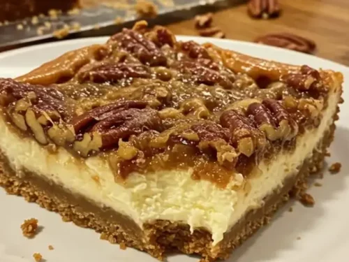 A close-up photo of a slice of Pecan Pie Cheesecake Bar, revealing its layered composition, on a simple white plate, amidst a baking scene.